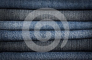 A pile of different types of blue denim jeans clos