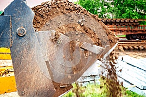 A pile of dirt sits next to a large shovel in a construction site. loader