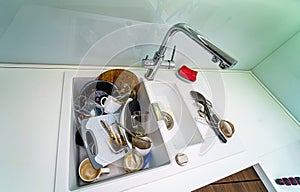 Pile of dirty dishes in the sink. Plates need washing. Kitchen sink with dirty plates.