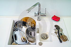 Pile of dirty dishes in the sink. Plates need washing. Kitchen sink with dirty plates.