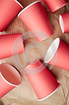 pile of disposable red paper cups on paper background. eco friendly concept. look from above. background backdrop