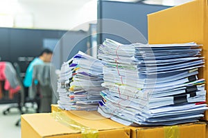 Pile of documents on desk stack up high waiting to be managed