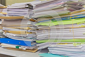 Pile of documents on desk stack up high waiting to be managed