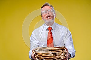 Pile of documents in hands. Senior man holding piles of documents paper work. Surprised of hard mental work