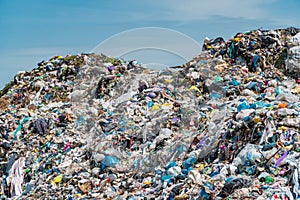 Pile of domestic garbage in landfill dump site. A pile of garbage in a landfill against a blue sky