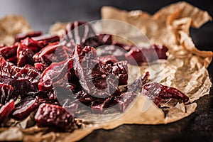 A pile of dried beef jerky pieces on paper and cutting board