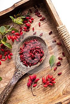 Pile of dried Berberis vulgaris also known as common barberry, European barberry or barberry on plate in home kicthen.