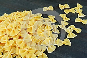 Pile of Dried Bow-tie Shaped Pasta Called Farfalle on Black Wooden Table