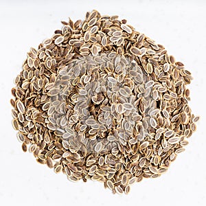 Pile of dried dill seeds close up on gray