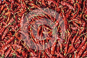 Pile of dried red chilli peppers texture background. Close up. Traditional vegetable market in Bangkok, Thailand.