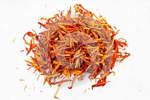 Pile of dried safflower petals close up on gray