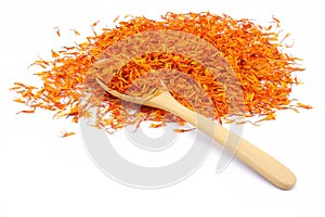 A pile of Dried Safflower petals herb Tea and a wooden spoon.