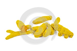 Pile of dried turmeric rhizomes on a white