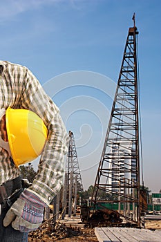 Pile driver works to set precast concrete piles in a constructi