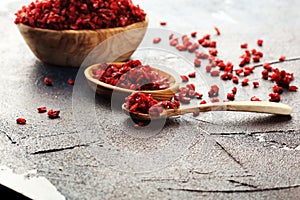 Pile of dry barberries in a wooden bowl on rustic table