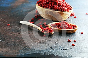 Pile of dry barberries in a wooden bowl on rustic table