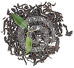 Pile of dry black tea with green leaves isolated on white background, top view