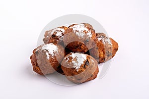 A pile of Dutch traditional oliebollen (dough balls) with powdered sugar isolated on white background
