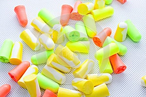 Pile of earplugs against noise in different colors isolated on white background.