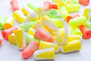 Pile of earplugs against noise in different colors isolated on white background.
