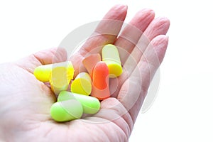 Pile of earplugs against noise in different colors in palm