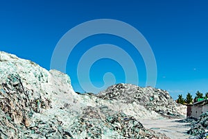 Pile of ecycle pieces of broken glass under blue sky