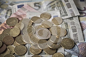 Pile of Euro coins on euro bank money notes of 5, 10 and 20 euro.