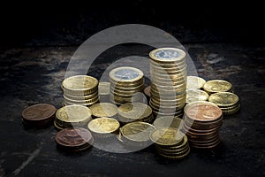 Pile of euro coins with high contrast and ighting seen from above with a black background