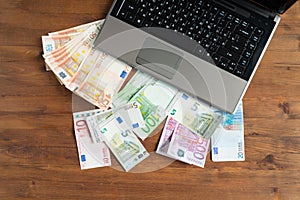 Pile of euro money with Laptop