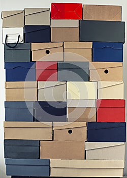 Pile of evenly folded shoe boxes against a white wall. Seasonal sales and discounts