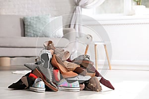 Pile of female shoes on floor indoors.