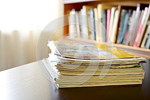 Pile of files with a bookshelf in the background