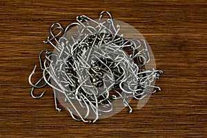 Pile of Fishing Hooks on an Old Polished Wooden Surface