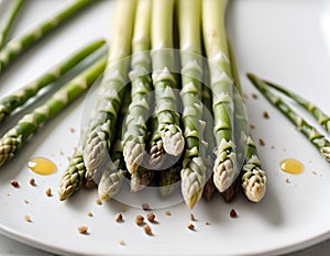 A pile of fresh asparagus on a white plate, top view.