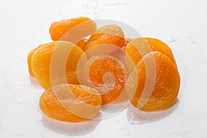 Pile of fresh dried apricots on white background, washed fruits in water , macro photo close up.