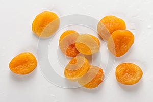 Pile of fresh dried apricots on white background, washed fruits in water , macro photo close up, top view.