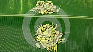 Pile fresh green chilies on a banana leaf