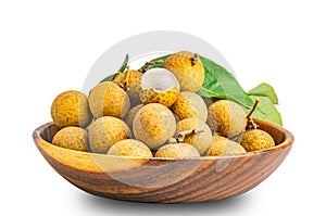 Pile of fresh longan fruit whole and a half peeled with green leaf in wooden bowl isolated on white background