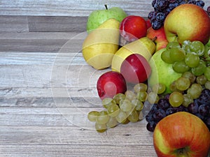 A pile of fresh organic autumn fruit on bleached  oak wood background. Healthy diet / fruit / food. Orchard crop / production / ha