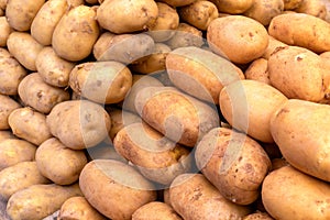 Pile of fresh potatoes on sale in vegetable stand display at the bazaar