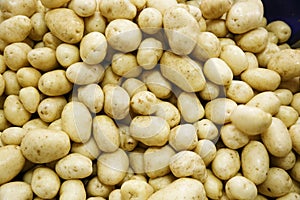 Pile of fresh, raw potatoes, textured background