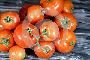 Pile of fresh red tomatoes vegetables  on wooden background, selective focus of fresh raw organic tomato, healthy food