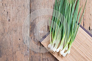 Pile of fresh spring onion on wood table