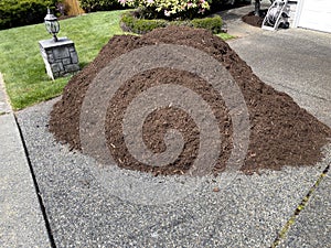 Pile of fresh topsoil in home driveway for lawn maintenance