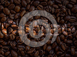 Pile of freshly roasted coffee beans background with German "Kaffee" text