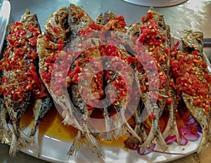 pile of fried fishs with spicy red hot chili sauce, on a plate