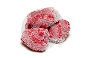 Pile of frozen raspberries on a white background closeup
