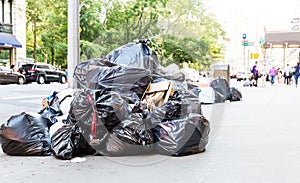 Pile of garbage bags on city street.