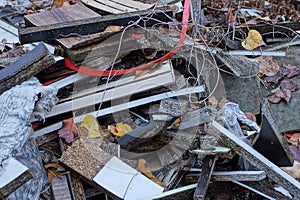 A pile of garbage from pieces of white and brown boards and metal scraps