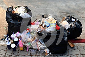 Pile of Garbage plastic black and trash bag waste many on the footpath, pollution trash, Plastic Waste and Bag Foam tray Garbage